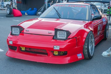 Beton yüzeyde kırmızı spor araba, arka kanat spoiler, vücut kiti ve aerodinamik bileşenler Vibrant kırmızı renk, sıcak STUNT metni Kyiv, Ukrayna - 21 Eylül 2025