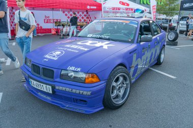 Açık havada mavi BMW E21 araba, açık kaput, yarış metni, canlı mavi kaporta, gümüş jantlar, doğal aydınlatma, yumuşak gölgeler, gizli tarz Kyiv, Ukrayna - 21 Eylül 2025
