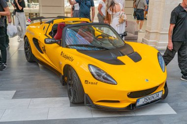 Siyah aksanlı sarı McLaren benzeri spor araba, parlak, kapalı bir galeri veya sergi alanında sabit parlak ışıklar Kyiv, Ukrayna - 21 Eylül 2025