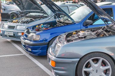 Açık kapüşonlu bir Volkswagen Golf GTI ön planı, klasik metalik bir araba, Ukrayna 'nın başkenti Kyiv' den 21 Eylül 2025 'te yola çıktı.