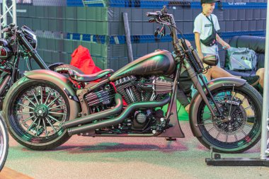 Üç Harley-Davidson motosikleti kapalı bir alanda sergileniyor, muhtemelen bir fuar veya sergi merkezi bisiklet krom aksanlı siyahtır, e Kyiv, Ukrayna 'dan dolayı asfalt askılı - 21 Eylül 2025
