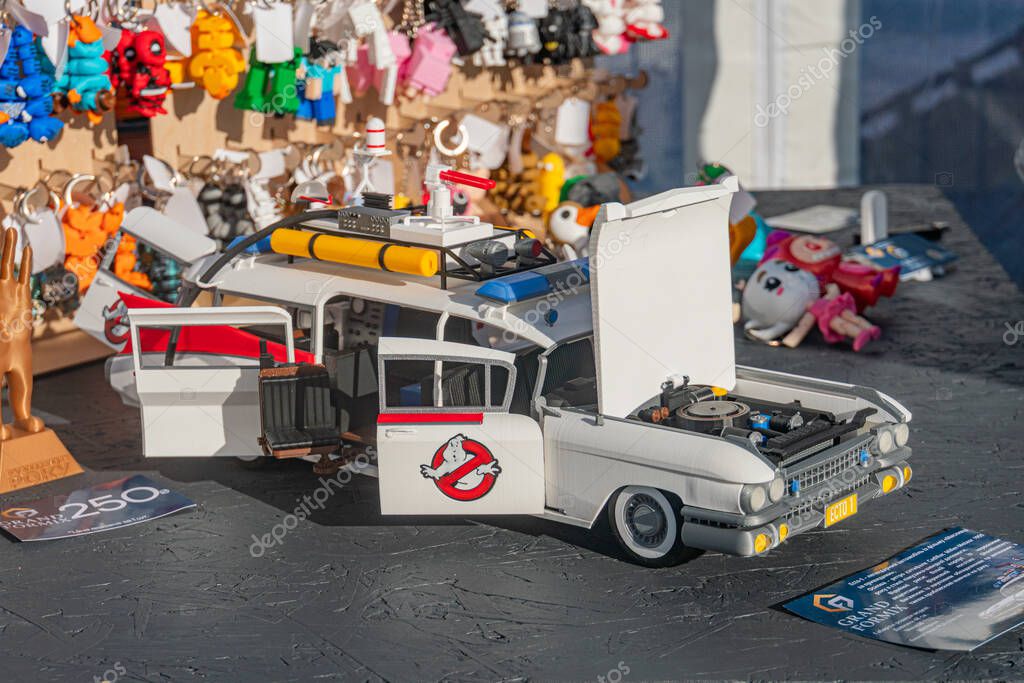 White Ghostbusters toy car with blue graphics and black interior, placed against a blurred backdrop of toy display setting Details on equipment bay are indistinct Kyiv, Ukraine - September 21, 2025