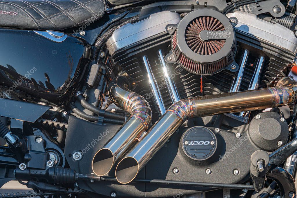 Close-up view of Harley-Davidson motorcycle engine and exhaust system under bright lighting, with cylindrical pipes extending outward Kyiv, Ukraine - September 21, 2025