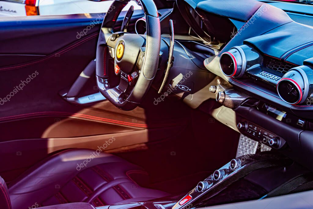 Interior view of a luxurious Ferrari from drivers seat, featuring a central leather-wrapped steering wheel with logo, black and gray color scheme, advanced dashboar Kyiv, Ukraine - September 21, 2025