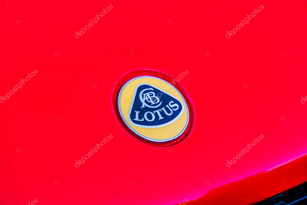 Close-up view of a red Lotus cars side rear fender, focusing on the yellow oval logo with a black outline and stylized L Outdoor setting with soft shadows, poten Kyiv, Ukraine - September 21, 2025