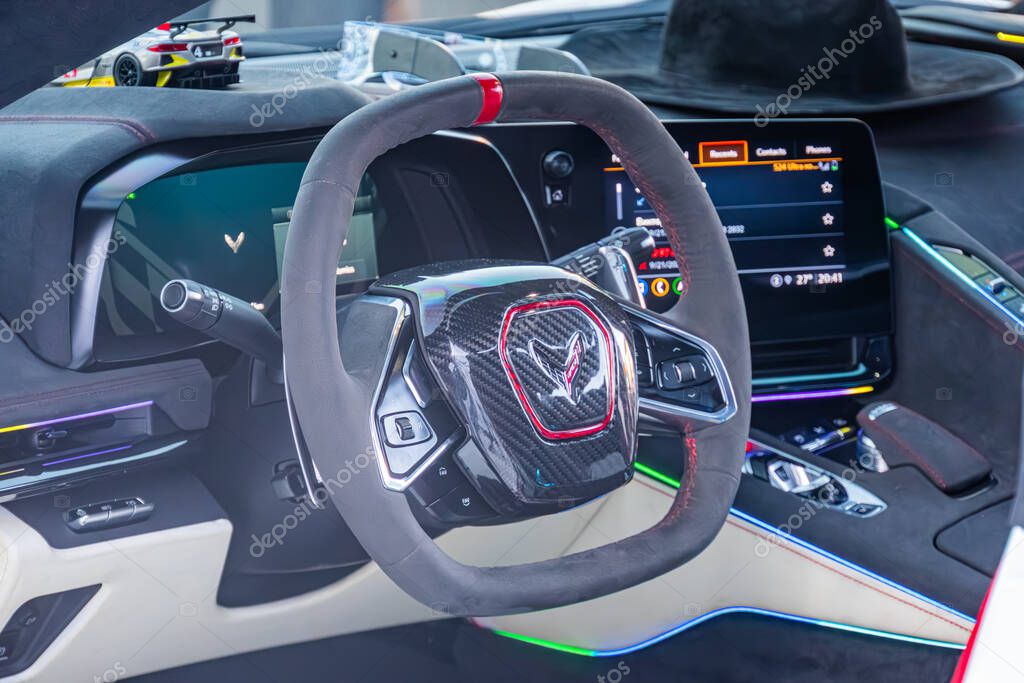 Close-up of a luxury Corvettes dashboard, showcasing the sleek steering wheel with brand logo and stitching, illuminated displays in blue and green, angled overhead Kyiv, Ukraine - September 21, 2025