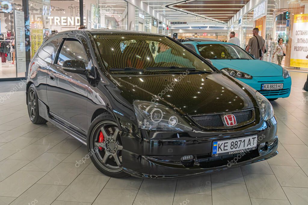 Modern indoor setting possibly car showroom, black Honda Civic Type R, aerodynamic side skirts, large rear wing spoiler, sporty front bumper with air intakes, blac Kyiv, Ukraine - September 21, 2025