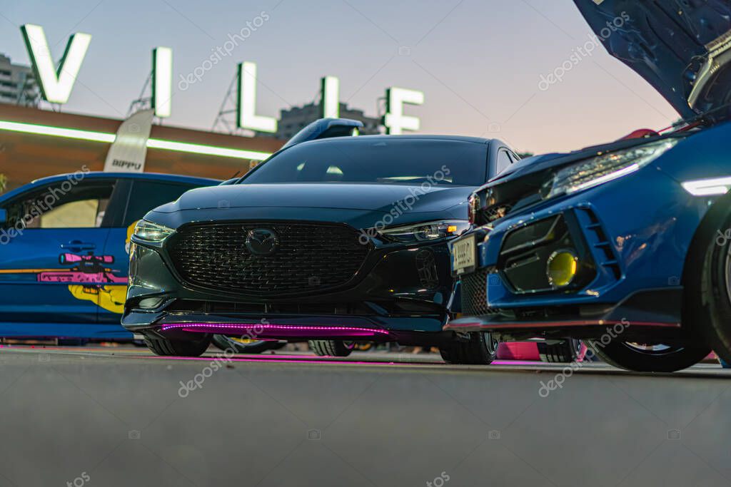 Indoor car show event in Vancouver, featuring a panoramic view of Mazda cars Dark-colored sedan and blue sports car dominate the frame, with distinctive design elem Kyiv, Ukraine - September 21, 2025