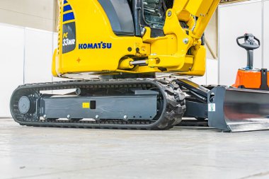 Sarı Komatsu motor gradyatörü, kavisli ön bıçak tozu ya da temel enkaz etrafında bulunan markalı Komatsu Large makinesi yapay ışık Kyiv, Ukrayna 'nın yumuşak gölgeleri - 14 Ekim 2025