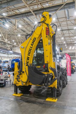 Kyiv, Ukrayna - 14 Ekim 2025, Kyiv, Ukrayna - Siyah yükleyici eklentisi ile donatılmış CASE İnşaat etiketli, kapalı beton zemin üzerinde sabit sarı Vaka İnşaat aracı