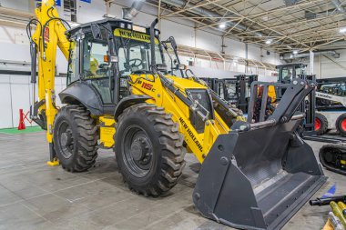 Sarı bir inşaat buldozerinin kapalı bir görüntüsü, markalı, raylar ve kürek ile donatılmış yapay ışıklandırma, arka planda kısmen belirsiz makineler, ön Kyiv, Ukrayna - 14 Ekim 2025