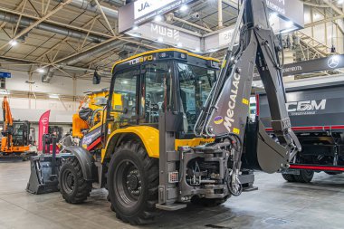 Tırtıl kazıcısının ve çeşitli renklerde ağır makinelerin yer aldığı kapalı sergi sarı, siyah, yeşil, mavi, turuncu Peo Kyiv, Ukrayna - 14 Ekim 2025