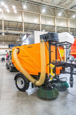 Turuncu endüstriyel zemin temizleme makinesi, muhtemelen bir depo ya da endüstriyel bina. Makinenin Kyiv, Ukrayna 'da önemli bir fırça montajı var. 14 Ekim 2025