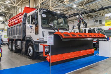 Temiz bir depo veya sergi alanı içinde turuncu güvenlik bariyerleri olan büyük beyaz sanayi kamyonu genişletildi ve Kyiv, Ukrayna - 14 Ekim 2025