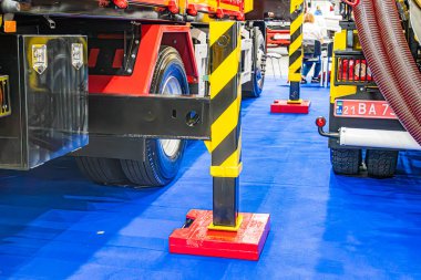 Büyük endüstriyel atölye ya da depo, yüksek tavan, biri kırmızı ve siyah iki kamyon, biri mavi döşemeli sarı, 4X2 işaret, sarı güvenlik bariyeri, yüksek Kyiv, Ukrayna - 14 Ekim 2025