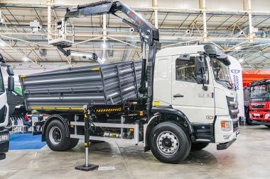 Diğer endüstriyel araçlarla dolu bir depoda bulunan beyaz kamyon vinci yüksek tavana, metal kirişlere, beton zemine ve pencerelere sahip ve doğal lig Kyiv, Ukrayna - 14 Ekim 2025