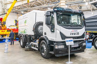 Modern beyaz ve siyah ticari bir aracın kapalı alanda sergilenmesi. Büyük ızgara, far ve kısmi mavi markalı parlaklığı var. Hatta Ukrayna 'nın Kyiv şehrinde 14 Ekim 2025' de ışıklandırma bile var.