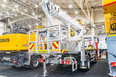 Beton zemin üzerine park edilmiş üç büyük, sarı ve beyaz kamyon vinçli sanayi deposu. Sağlam metal dış yüzeyli ve off-Kyiv, Ukrayna - 14 Ekim 2025