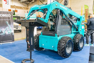 Mavi Yale forklifti bir endüstriyel serginin mavi halılı zemininde diğer kabinler, karanlık makineler ve parlak ışıklandırma Kyiv, Ukrayna - 14 Ekim 2025