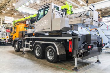 Endüstriyel garaj atölyesi sahnesi iki yeşil renkli taşıma aracı, vinç kamyonu ve başka bir kaldırma makinası ile Kyiv, Ukrayna - 14 Ekim 2025