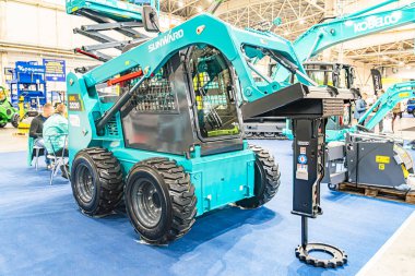 Endüstriyel ekipmanlar, mavi bir John Deere tele idarecisinin sarı bir forklift ve ek olarak Kyiv, Ukrayna - 14 Ekim 2025