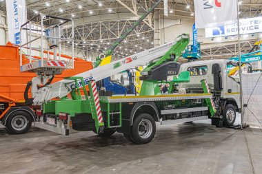 Depo ya da endüstriyel tesis. Vinç sistemi, kazı kovası ve vişne toplayıcı takılı yeşil kamyonet. Yumuşak sh Kyiv, Ukrayna - 14 Ekim 2025