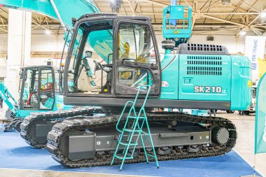 Sanayi aracı SK20D mavi yüzey üzerinde turkuaz renkli, floresan ışıklandırma arka planı yapı Kyiv, Ukrayna - 14 Ekim 2025