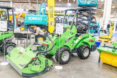 Çimenlik ve bahçe ekipmanlarını gösteren sanayi deposu, öncelikli olarak motorlu çim biçme makineleri ve traktörler dahil olmak üzere yeşil makineler, Ppe Kyiv, Ukrayna ile ön planda düzenlenmiştir - 14 Ekim 2025