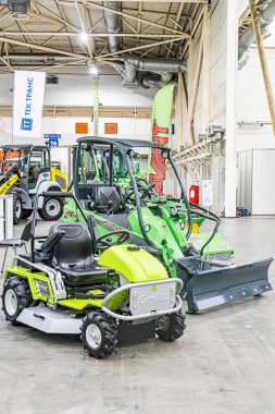 Kapalı alanda, Ukrayna 'nın başkenti Kyiv' de 14 Ekim 2025 'te suni aydınlatma ve cilalanmış beton zeminde iki adet sarı özel makine buldozeriyle birlikte endüstriyel sahne.