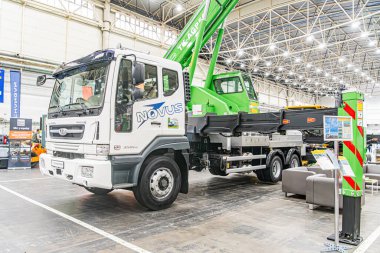 Doğal ışıklandırmalı sanayi alanı, vinç forklift merkezi park yeri, beton zemin, bulutlu gün, mavi çizgili beyaz taksi, Avrupa belediyesi t Kyiv, Ukrayna - 14 Ekim 2025