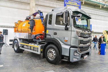 Büyük turuncu ve beyaz araç gereçleri kapalı alanda, muhtemelen bir sergi salonu ya da endüstriyel depo. Arka planda insanlar var, Kyiv, Ukrayna - 14 Ekim 2025