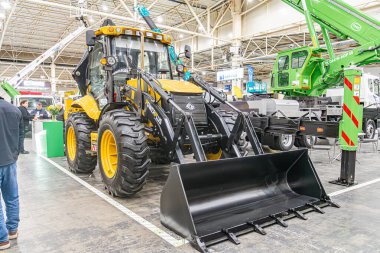 İç mekan, depo veya büyük atölye, işaretli beton zemin, metal kirişler ve sütunlarla desteklenen yüksek tavanlar, Kyiv, Ukrayna ile sarı kepçe doldurucu - 14 Ekim 2025