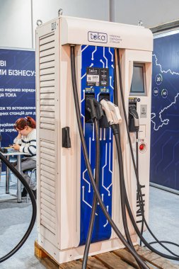 Modern mavi-beyaz elektrik şarj istasyonu, Kiril alfabesiyle yazılmış metin, dijital ekran kapalı, kapalı ışık ve kısmen görünür bir Kyiv, Ukrayna - 14 Ekim 2025