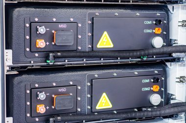 Kırmızı ve turuncu bağlantıları olan siyah plastik bir elektrik cihazının yakın plan görüntüsü, sarı uyarı etiketli, gerçekçi tarzda, hatta Kyiv, Ukrayna - 14 Ekim 2025