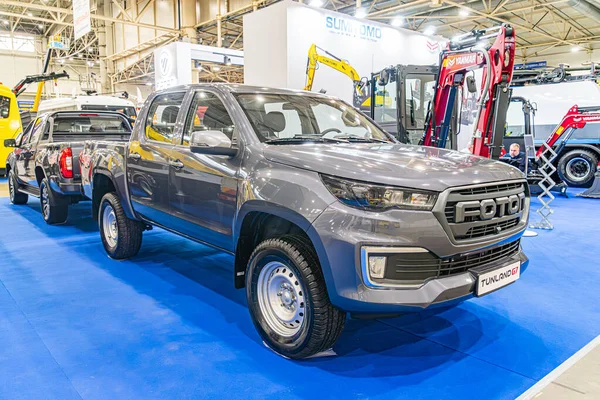 Mavi halılı zemin, iki sağlam dört çekerli araç yan yana, biri ön ızgaraya bakan, diğeri daha büyük, arkası daha küçük, sanayi tipi Kyiv, Ukrayna - 14 Ekim 2025