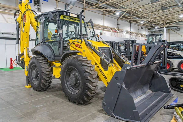 Sarı bir inşaat buldozerinin kapalı bir görüntüsü, markalı, raylar ve kürek ile donatılmış yapay ışıklandırma, arka planda kısmen belirsiz makineler, ön Kyiv, Ukrayna - 14 Ekim 2025