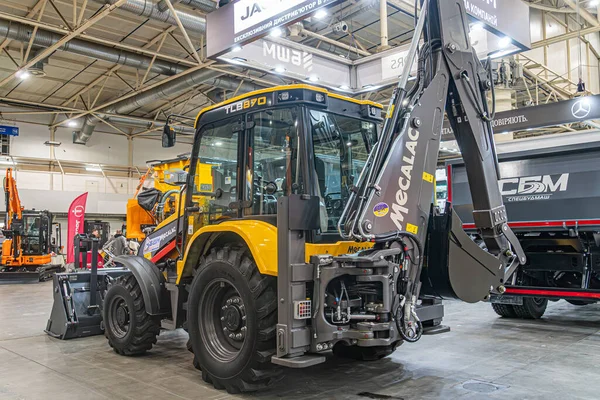 Tırtıl kazıcısının ve çeşitli renklerde ağır makinelerin yer aldığı kapalı sergi sarı, siyah, yeşil, mavi, turuncu Peo Kyiv, Ukrayna - 14 Ekim 2025