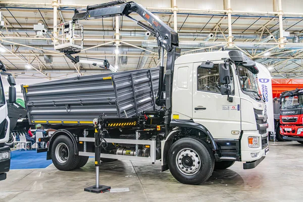 Diğer endüstriyel araçlarla dolu bir depoda bulunan beyaz kamyon vinci yüksek tavana, metal kirişlere, beton zemine ve pencerelere sahip ve doğal lig Kyiv, Ukrayna - 14 Ekim 2025