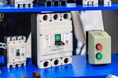 Mavi yüzeyde çeşitli beyaz cihazlara sahip endüstriyel elektronik sergi, farklı tasarımlar, boyutlar ve özellikler, yeşil etiketli merkezi büyük cihaz ve Q Kyiv, Ukrayna - 14 Ekim 2025