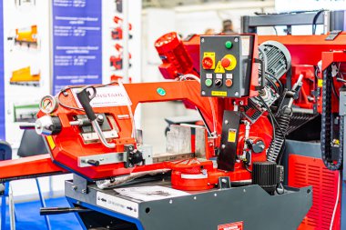 Beyaz bir makine kullanan büyük kırmızı robot kollu sanayi sahnesi arka planı doldurarak derinlik ve karmaşıklık yaratan yapay ove Kyiv, Ukrayna - 14 Ekim 2025