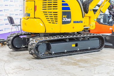 Siyah çizgili sarı kazıcının kapalı bir fotoğrafı, taksi tarafında mavi harfli marka makine ön tarafta büyük bir kova var Kyiv, Ukrayna - 14 Ekim 2025