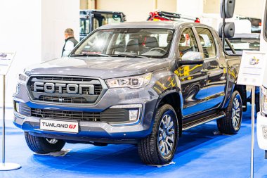 Kapalı otomobil fuarı veya sergisi Gray Toyota Land Cruiser V8, sağda, mavi zemin üzerinde belirgin yuvarlak farlar, büyük ön ızgara, gümüş yan aynalar, fi Kyiv, Ukrayna - 14 Ekim 2025