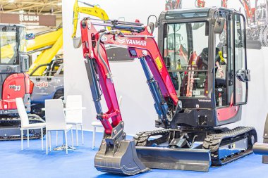 Sanayi makinelerinin mavi halılı zeminde görüntülenmesi, merkezi kırmızı kazıcı ve ikincil yeşil kazıcı kısmi görüntüsü, hepsi de Kyiv, Ukrayna - 14 Ekim 2025