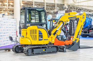 Kapalı alanda, Avrupa belediye taşımacılığı, mavi aksanlı iki sarı kazıcının yer aldığı, hatta hidrolik kolları olan temiz makineleri aydınlatan Kyiv, Ukrayna - 14 Ekim 2025