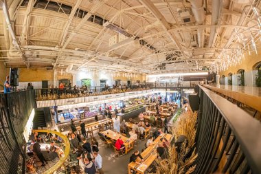 Kyiv Gıda Pazarı hareketli restoran, endüstriyel ve modern elementlerin eklektik iç karışımı, doğal ışığa sahip büyük pencereler, açıkta olan yüksek tavan, Kyiv, Ukrayna - 19 Eylül 2025