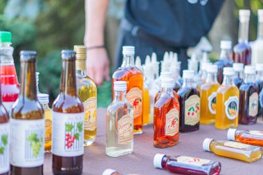 Canlı bir açık hava etkinliğinde, çeşitli şekilleri ve Kyiv, Ukrayna - 20 Eylül 2025 tarihli, çeşitli şekilleri gösteren, içecekler ve yağlarla dolu renkli halk şişeleri ve kavanozlarından oluşan seçkin bir masa yer alıyor.