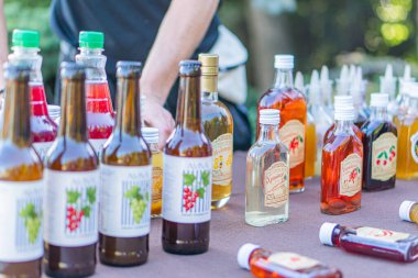 18 şarap şişesi, koyu yeşil cam, zıt masa yüzeyi, görüntü çözünürlüğü, dekoratif balmumu kapakları, sıcak ışıklandırma, Kyiv, Ukrayna - 20 Eylül 2025