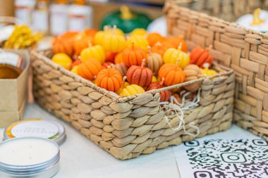 Beyaz giysili bir sepet dolusu turuncu ve yeşil balkabağı var. Kabak bitişiğinde de bilinmeyen beyaz bir konteynır var. Çevre aydınlatması Kyiv, Ukrayna - 25 Eylül 2025