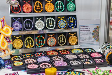 Ukrayna fuarında boncuklu mücevherlerin sergilendiği masa, parlak renkte bilezikler ve kolyeler ile el yapımı Kyiv, Ukrayna - 25 Eylül 2025