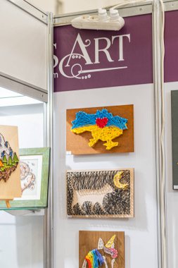 Sergi kabininde, Ukrayna 'daki bir panayırda çerçeveli halk eserleri sergilenirken, çeşitli hayvan çizimleri, kuş, at, muhtemelen canlı renklerde kurt köpekleri Kyiv, Ukrayna - 25 Eylül 2025